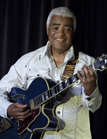 Phil Upchurch soloing on a dimly lit stage